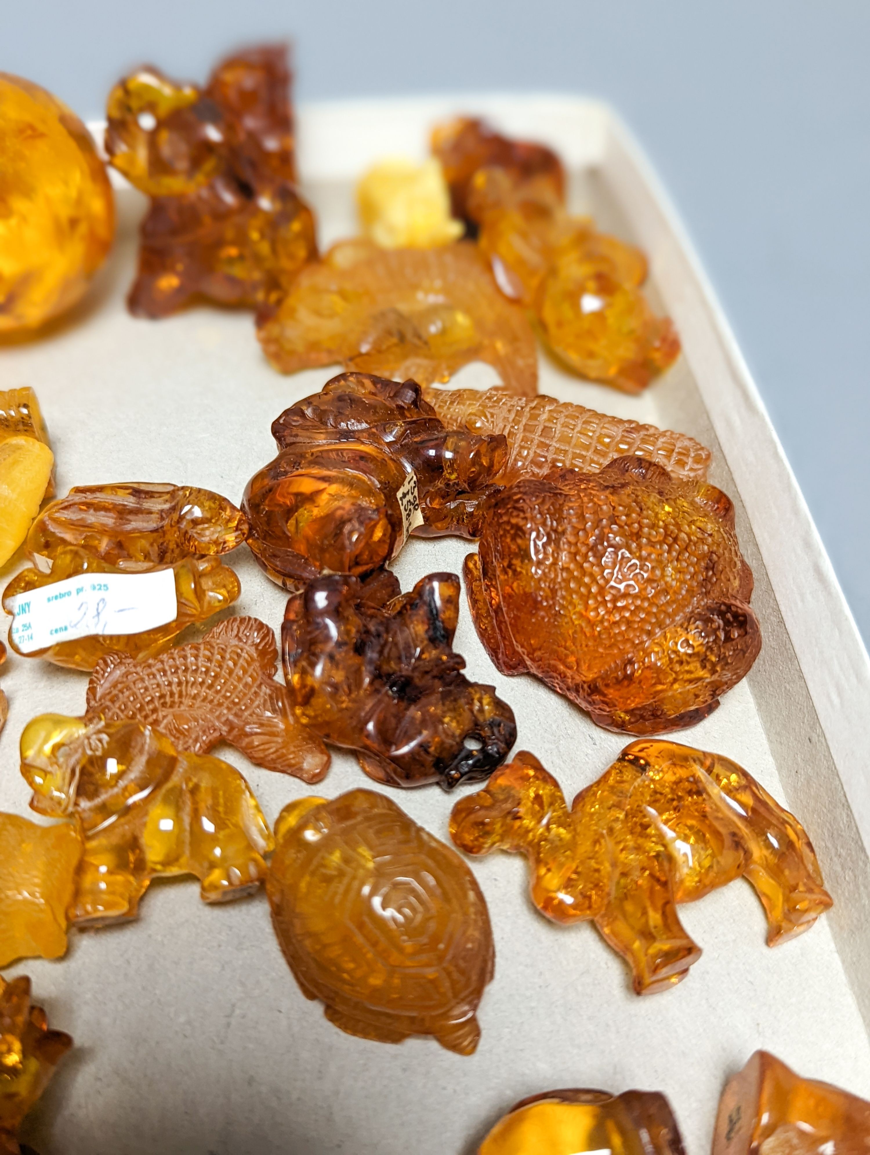 A mixed collection small carved amber wares including dice, eggs and cigarette holders, etc.